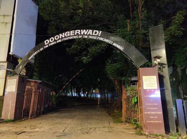 Photo of an arched gateway by night. This is the entrance of the Tower of Silence in Malabar Hill, Mumbai