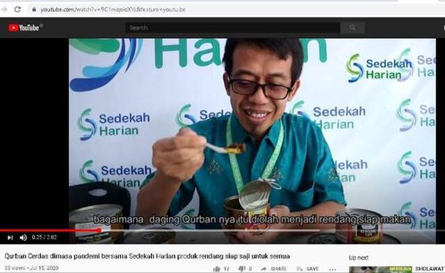 Screenshot of a video shows a man holding a spoon of the canned qurban meat