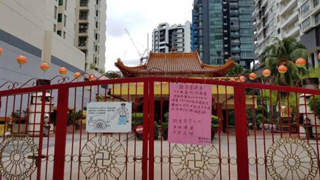 Photo showing the closed gates of a Chinese temple with handwritten notices placed on the gate. This is a  vegetarian hall in Balestier area of Singapore which remained closed to public during the Circuit Breaker Period.
