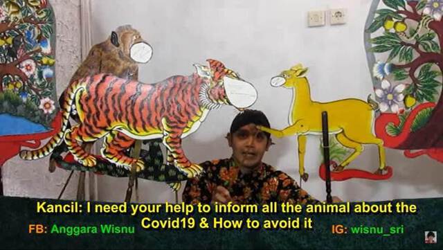 Still image of a Javanese puppeteer holding the colorful puppets representing a monkey, a tiger and a deer. Screenshot from wayang kancil performance by Ki Anggara Sri Wisnu (2020) posted on YouTube.